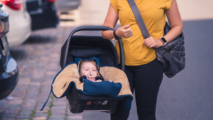 Sleepbag autostolspose med baby i en løftet autostol
