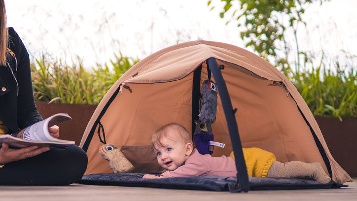 Baby liggende på maven på Sleepbag aktivitetstæppe, som kan hjælpe med at undgå overstimulering af baby